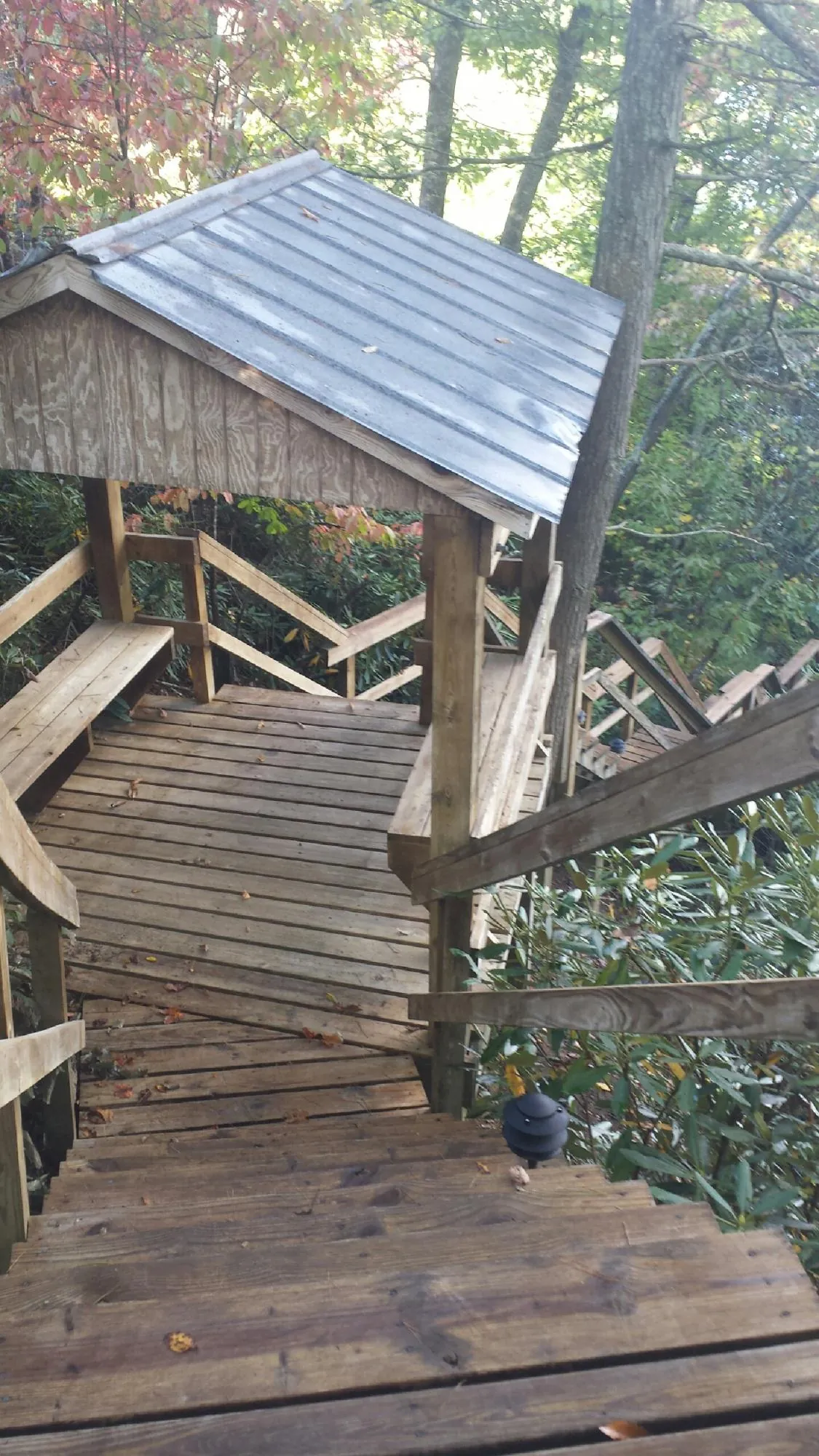 Metal roofed shelter over wooden steps on a wooded walkway — Skylight Repair & Installation work by our crew in Brunswick